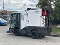A 2019 Madvac LS175 street cleaning machine with a compact design featuring front brushes and a rear-mounted vacuum system