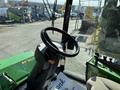 The interior of a 2021 John Deere 1575 featuring a steering wheel dashboard controls and a note on the seat