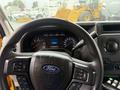 Steering wheel and dashboard of a 2021 Ford Econoline displaying gauges and controls