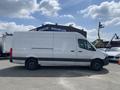 A white 2024 Mercedes-Benz Sprinter van with a high roof and cargo space visible from the side