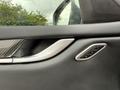 Close-up of the interior door handle of a 2016 Maserati Ghibli featuring a sleek design with metallic accents and controls for seat adjustments