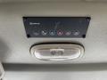 Control panel with buttons for temperature settings and ventilation functions above a light fixture in a vehicle