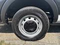 A close-up view of a black wheel with a silver hubcap mounted on a 2019 Ford Transit 350 tire