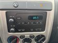 The dashboard of a 2011 Chevrolet Colorado featuring a radio display with buttons for AM FM and volume controls along with climate controls displayed below