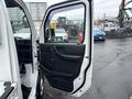 A white 2010 Suzuki Carry with an open driver's side door showcasing the interior features and black door panel