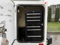 A 2015 Ford F-450 with a closed tool compartment showcasing a black tool chest with seven drawers arranged vertically