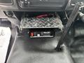 A 2016 RAM 1500 dashboard with a mounted metal shelf and a WHILEN control panel featuring buttons and indicator lights