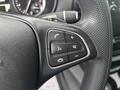 Close-up of a steering wheel control panel featuring buttons for phone, volume, and audio settings in a 2021 Mercedes-Benz Metris