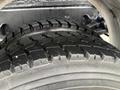 Two heavy-duty tires with deep tread patterns stacked on each other, showing signs of wear typical for a 2016 Freightliner 108SD truck