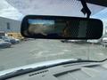 A 2022 GMC Savana viewed from the driver's perspective with a rearview mirror reflecting a screen displaying a rear camera feed