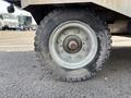 A close-up of a tire from a 2023 Bitimec SC415 featuring a rugged tread design and metal rim