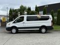 White 2017 Ford Transit T150 XLT van with a large window on the side and a colorful umbrella attached to the roof