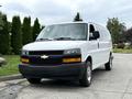 A 2021 Chevrolet Express van in white with a black front grille and chrome accents parked on a driveway