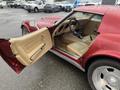 A red 1970 Chevrolet Corvette with an open door showcasing beige leather interior and steering wheel visible