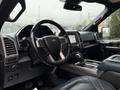 Interior view of a 2018 Ford F-150 showing the steering wheel dashboard and center console with infotainment display and controls