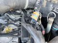 A close-up view of the engine components of a 2013 JCB 510-56 Loadall showing pipes wires and a fuel filter