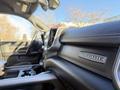 A close-up view of the interior of a 2023 RAM 3500 featuring the Laramie badge on the dashboard with leather upholstery and a modern console design