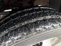 Close-up of a treaded tire of a 2011 Dodge Ram 5500 showing deep grooves and wet surface texture