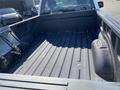The image shows the interior of a 2018 Ford F-150 truck bed featuring a textured surface with grooves and a plastic side wall