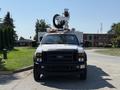 A white 2008 Ford F-550 truck with an elevated work platform and various attachments at the front, designed for utility or maintenance purposes
