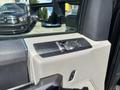 Close-up of the control panel for windows and mirrors in a 2022 Ford F-350 SD featuring buttons and a rotating dial