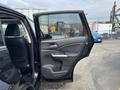 A black 2014 Honda CR-V with the front door open showcasing the interior door panel and seat