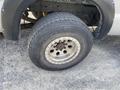 A close-up of a wheel from a 2007 Ford F-350 SD featuring a silver rim and a rugged tire with visible tread patterns