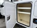 A white 2018 Ford F-550 service truck with an open storage compartment revealing two shelves inside