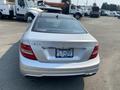 A silver 2013 Mercedes-Benz C-Class sedan with a sleek design viewed from the rear showcasing the taillights and the license plate