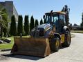 A 2013 John Deere 710K backhoe loader featuring a large front bucket and an extended hydraulic arm in a work-ready position