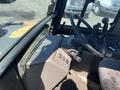 Interior view of a 2011 Case 570 MXT tractor showing the steering wheel control panel and seat with dirt on the floor