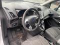 Interior view of a 2017 Ford Transit Connect showcasing the steering wheel dashboard and center console with gear shifter and cup holders