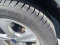 Close-up of a 2015 Ford Escape tire showcasing its tread pattern and a silver alloy wheel with the brand name Nokian Tyres visible on the sidewall