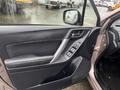 A 2016 Subaru Forester door interior featuring a black fabric and plastic panel with window controls and a silver handle