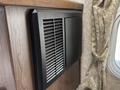 A black air vent with horizontal slats mounted on a textured surface of a 2018 Westland Travelaire