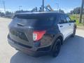 A 2020 Ford Explorer SUV in black and white with a sleek design and black rims parked on a gravel surface