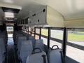 Interior of a 2009 International 3000 CE school bus featuring a row of gray seats and overhead storage compartments
