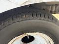 A close-up view of a tire on a 2012 Ford Econoline showing tread pattern and wear with a metal rim in the center