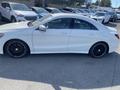 A white 2014 Mercedes-Benz CLA-Class parked with black alloy wheels and a sleek design