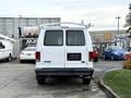 White 2008 Ford Econoline cargo van with a ladder rack on top facing forward