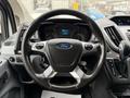 Steering wheel of a 2017 Ford Transit T150 XLT with controls and the Ford logo in the center