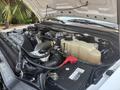 Engine compartment of a 2009 Ford F-450 Super Duty featuring a large diesel engine battery and various components including hoses and fluid reservoirs