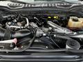 Engine bay of a 2017 Ford F-550 featuring a turbocharger intake pipe various hoses and a coolant reservoir