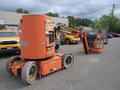 A 2009 JLG E300AJP aerial lift with a large orange platform and wheels positioned for operation