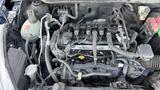 Engine compartment of a 2019 Nissan Kicks showcasing the engine assembly with various components including hoses wires and a coolant reservoir