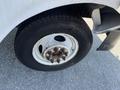Close-up of a tire and wheel from a 2012 Ford Econoline showing the rim and bolts with worn tread on the tire