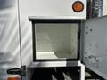A 2006 International 4300 truck with a large empty storage compartment and a side door open revealing the storage space inside