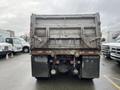 A 2003 International 5600i dump truck seen from the rear with visible tail lights, mud flaps, and dual rear wheels