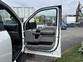 A 2017 Ford F-150 truck with an open driver's side door showing the interior door panel and seat