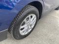 Close-up of a 2022 Chevrolet Equinox tire and alloy wheel showcasing a silver rim with a black tire tread pattern